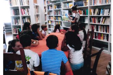 Bambini seduti ad un tavolo che ascoltano una favola